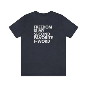May include: A dark blue t-shirt with white text that reads "FREEDOM IS MY SECOND FAVORITE F-WORD".