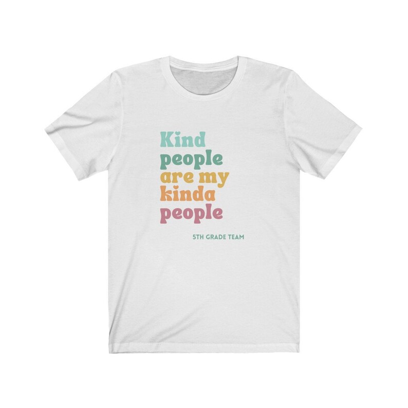 Pu&ograve; includere: Maglietta bianca con il testo "Kind people are my kinda people" in colori arcobaleno. Il testo "5th Grade Team" &egrave; stampato in un carattere pi&ugrave; piccolo sotto il testo principale.
