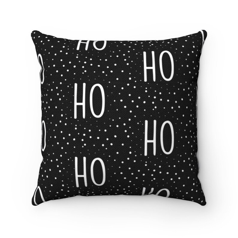 May include: Black and white throw pillow with a repeating pattern of white polka dots and the word "HO" in white.
