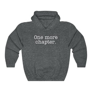 May include: A dark grey hooded sweatshirt with the text "One more chapter." printed in white on the front.