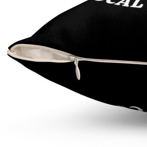 May include: Black pillow with a white zipper and the text "LOCAL" printed on it.