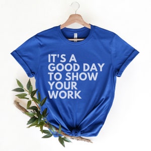 May include: A royal blue t-shirt with the text "It's a good day to show your work" printed in white.