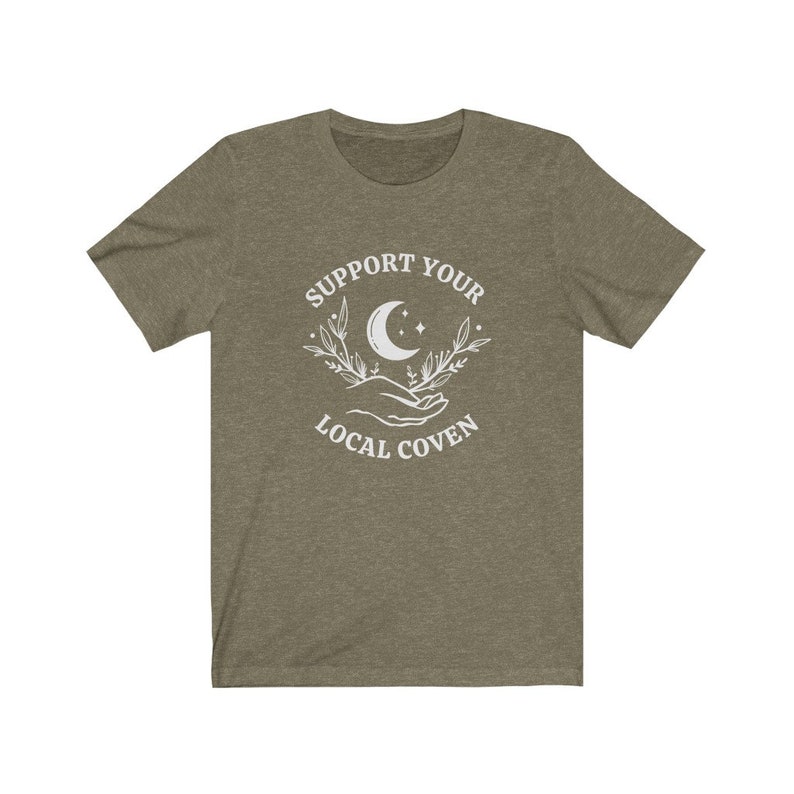 May include: A green t-shirt with a white graphic design that says "Support Your Local Coven" with a crescent moon and floral design.