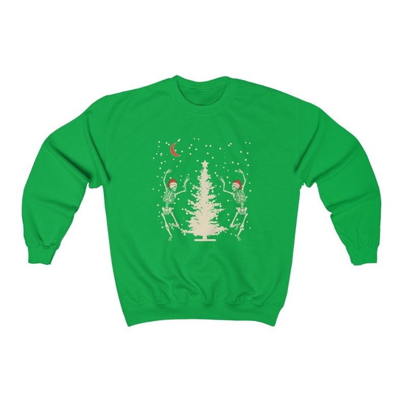 May include: Green Christmas sweatshirt with a white Christmas tree and two skeletons wearing Santa hats dancing around it. The skeletons are white with black outlines. There is a crescent moon and snowflakes in the background.