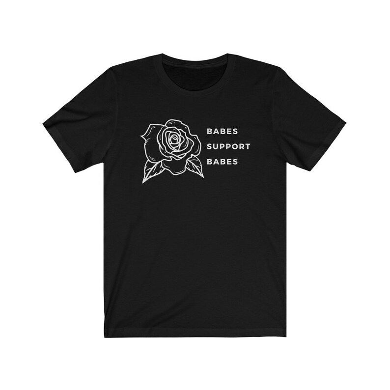 May include: Black t-shirt with a white rose graphic and the text "BABES SUPPORT BABES".