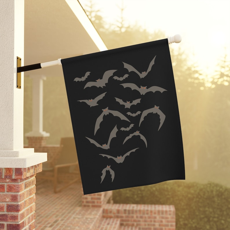 Puede incluir: Una bandera negra de Halloween con una silueta de murci&eacute;lagos volando en un cielo oscuro.
