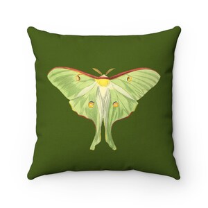 May include: A green and white luna moth with red accents is printed on a dark green throw pillow.