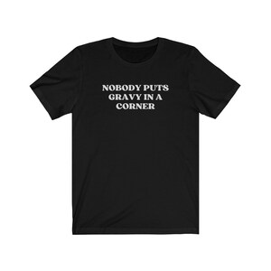 May include: Black t-shirt with white text that reads "Nobody puts gravy in a corner."