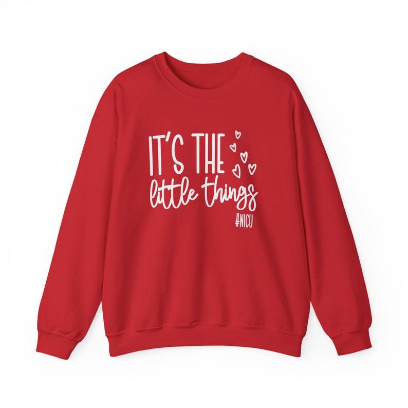 Może przedstawiać: Czerwona bluza z białym napisem "IT'S THE little things", ozdobiona małymi sercami. Hasztag #NICU znajduje się pod tekstem. Ten element odzieży jest odpowiedni na r&oacute;żne okazje.