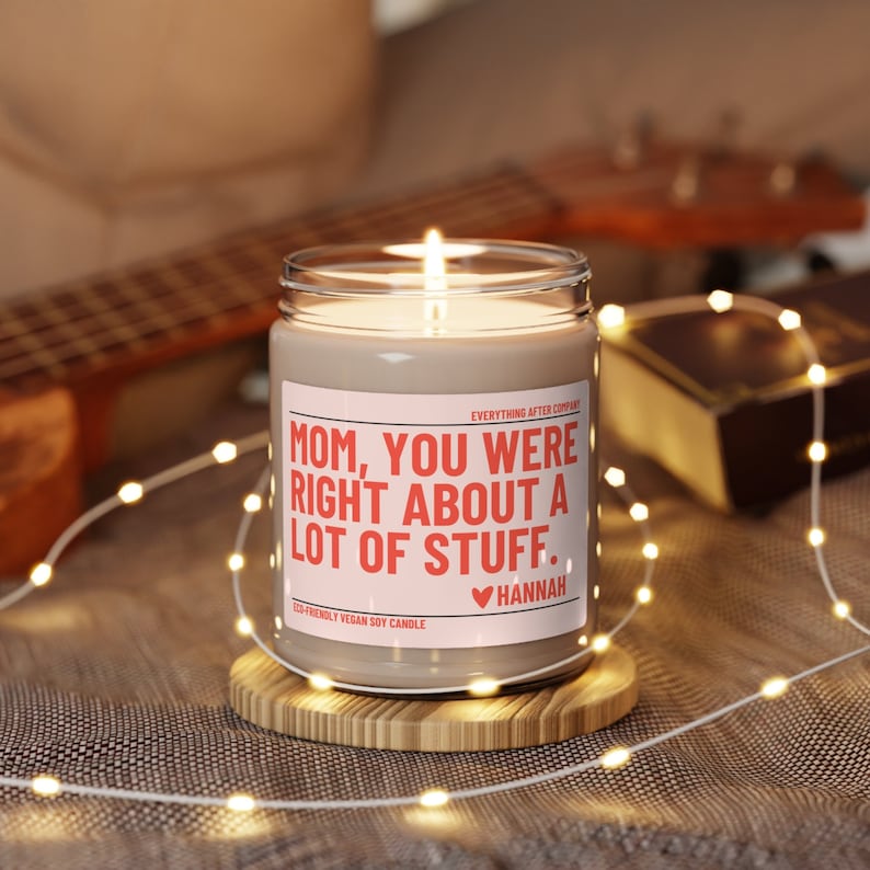 May include: A brown soy candle with a white label that reads "MOM, YOU WERE RIGHT ABOUT A LOT OF STUFF." The label also includes the text "ECO-FRIENDLY VEGAN SOY CANDLE" and a heart with the name "HANNAH".