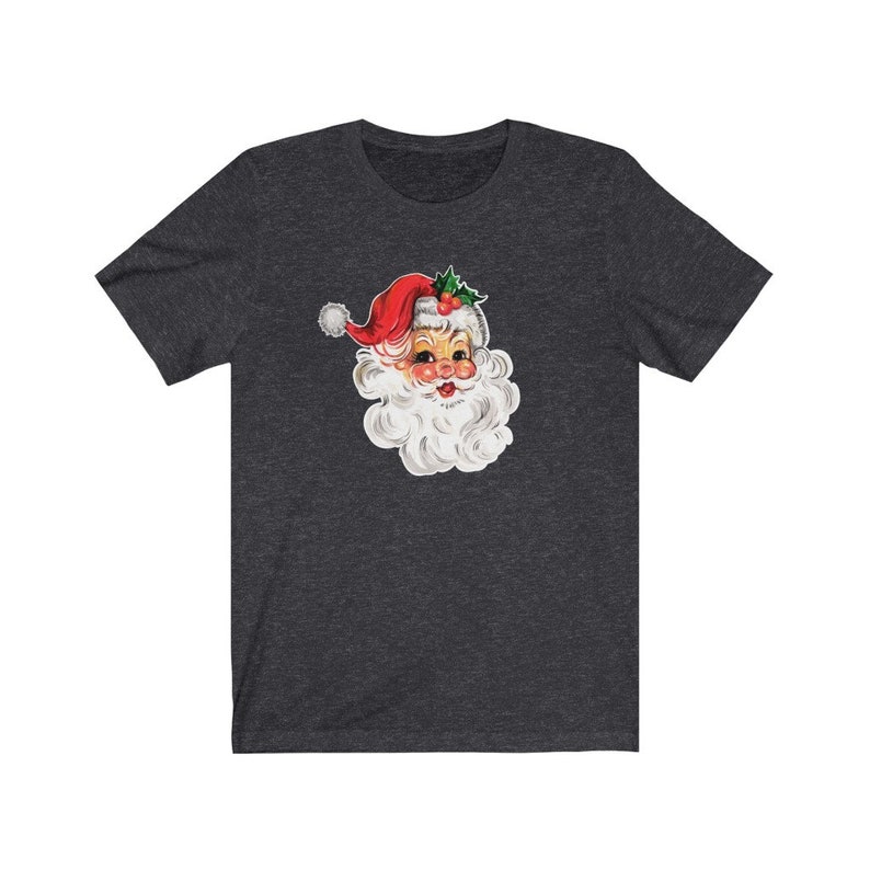 May include: A dark heather grey t-shirt with a vintage illustration of Santa Claus's face. The illustration features a red hat with white trim and a white beard.