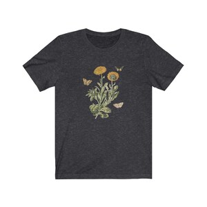 May include: A dark heather grey t-shirt with a vintage botanical illustration of a yellow flower with butterflies.