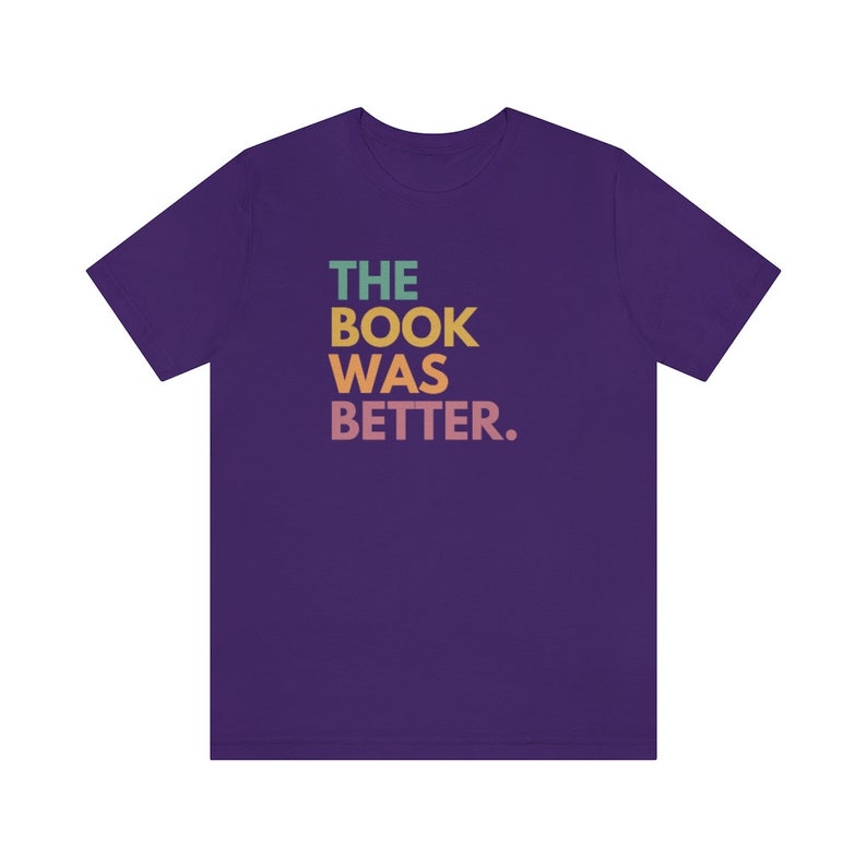 May include: Purple t-shirt with the text "THE BOOK WAS BETTER." in rainbow colors.