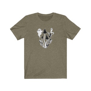 Puede incluir: Una camiseta verde con un gr&aacute;fico en blanco y negro de setas y fantasmas. El gr&aacute;fico est&aacute; centrado en la camiseta.