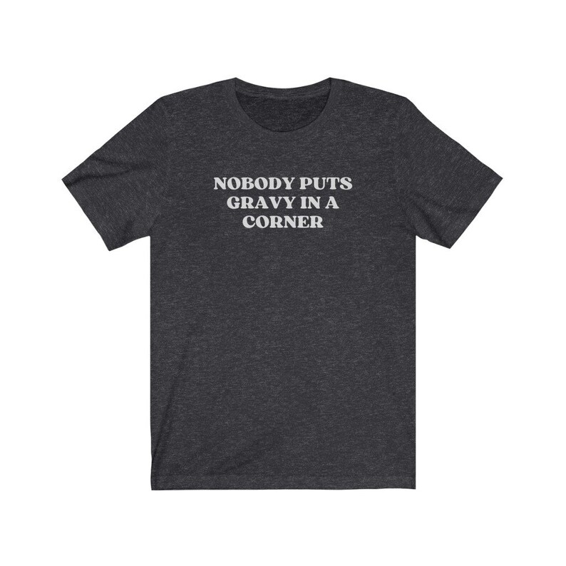 May include: Dark heather gray t-shirt with white text that reads "Nobody puts gravy in a corner".
