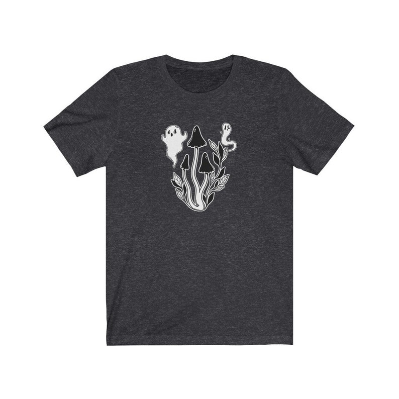 Puede incluir: Una camiseta gris oscuro jaspeada con un gr&aacute;fico blanco de fantasmas y setas. El gr&aacute;fico representa tres setas con tres fantasmas flotando sobre ellas.