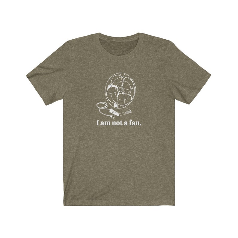 Peut inclure: Un t-shirt vert avec un contour blanc d'un ventilateur et le texte "Je ne suis pas un fan."