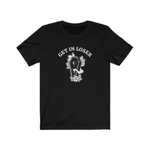 May include: Black t-shirt with white text that reads "GET IN LOSER" and a graphic of a coffin with a crescent moon and flowers.