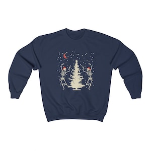 May include: Navy blue sweatshirt with a Christmas tree and two skeletons dancing around it. The skeletons are wearing Santa hats. The design is in a vintage style.