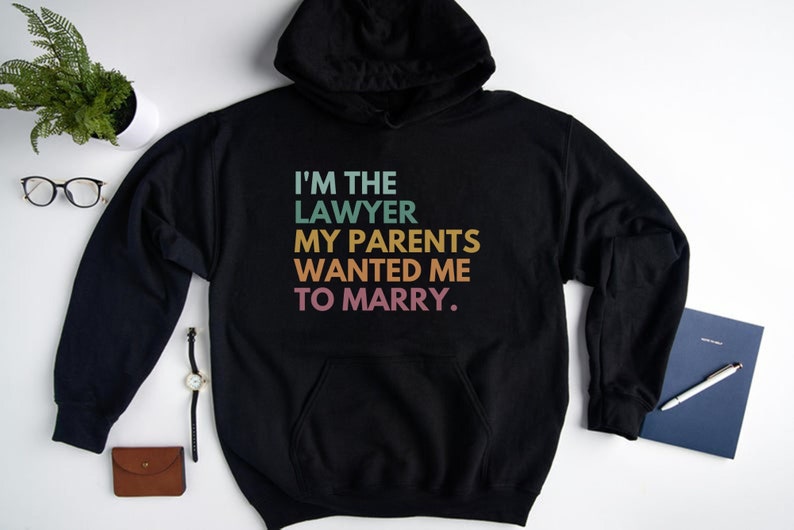 May include: Black hooded sweatshirt with the text "I'm the lawyer my parents wanted me to marry." in rainbow colors.