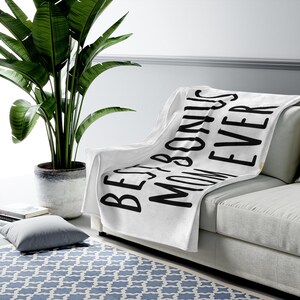 May include: White fleece throw blanket with black text that reads "Best Bonus Mom Ever".