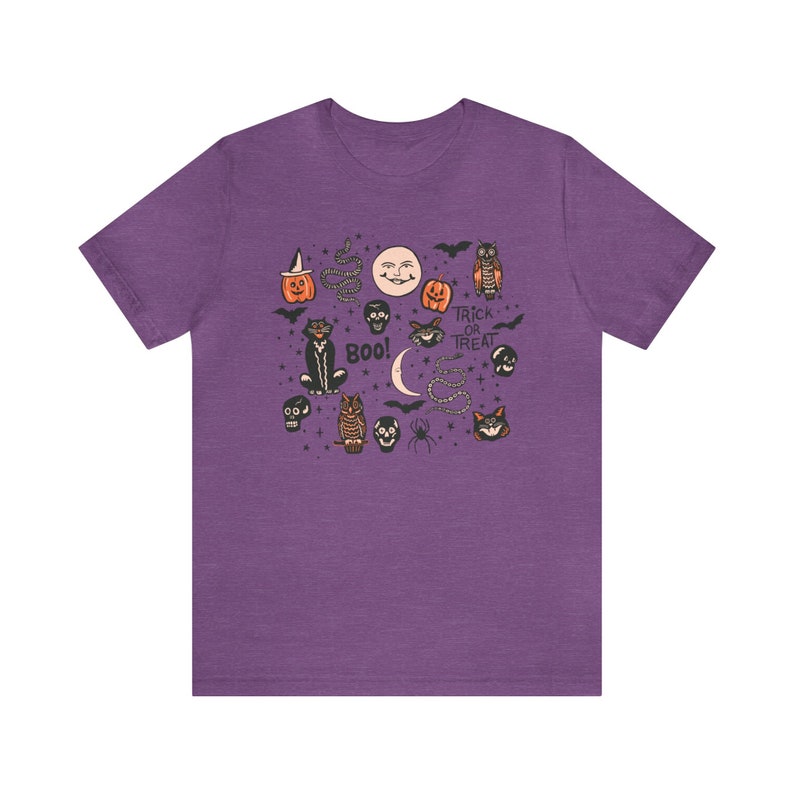 May include: Purple t-shirt with a vintage Halloween design featuring cats, owls, pumpkins, skulls, bats, and the text "Trick or Treat" and "Boo!"