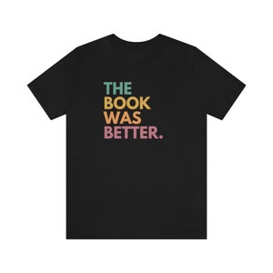 May include: Black t-shirt with the text "THE BOOK WAS BETTER." in colorful letters.