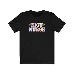 Peut inclure: T-shirt noir avec le texte "NICU NURSE" en lettres color&eacute;es avec des accents de paillettes.