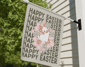 May include: A beige flag with the text "Happy Easter" repeated multiple times in a diagonal pattern. A white bunny rabbit with pink ears is surrounded by pink flowers.