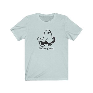 May include: A light blue t-shirt with a black cartoon ghost and the text "future ghost" printed on the front.