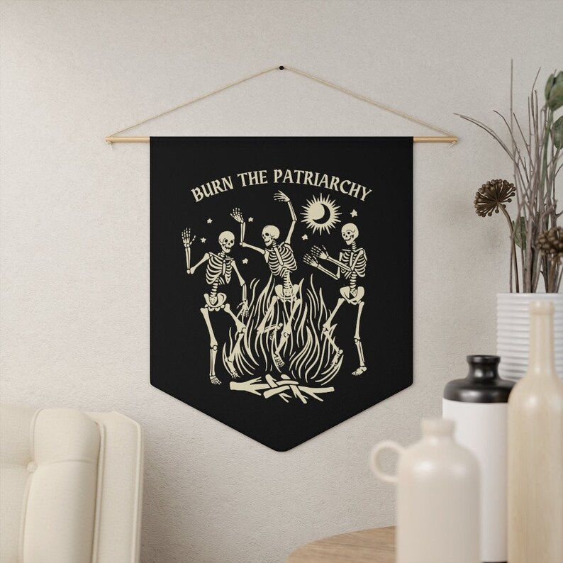 May include: Black tapestry with the text "BURN THE PATRIARCHY" in white. Three skeletons are dancing around a bonfire with a crescent moon and sun in the background.