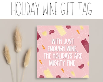 May include: Printable gift tag with a pink background and a white border. The tag features a pattern of wine bottles and glasses. The text on the tag reads "With just enough wine, the holidays are mighty fine."
