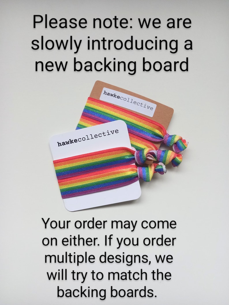 May include: Two rainbow elastic hair ties with the text "hawkecollective" on the backing cards. The text "Please note: we are slowly introducing a new backing board. Your order may come on either. If you order multiple designs, we will try to match the backing boards." is printed below the hair ties.