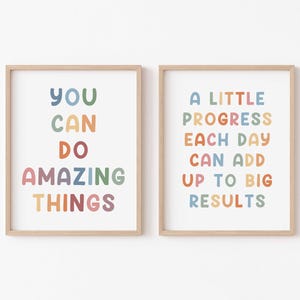 May include: Two framed prints with motivational quotes in colorful, rounded letters. The left print reads "You Can Do Amazing Things". The right print reads "A Little Progress Each Day Can Add Up To Big Results".