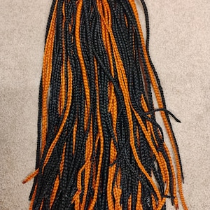 orange and black clip in braided ponytail