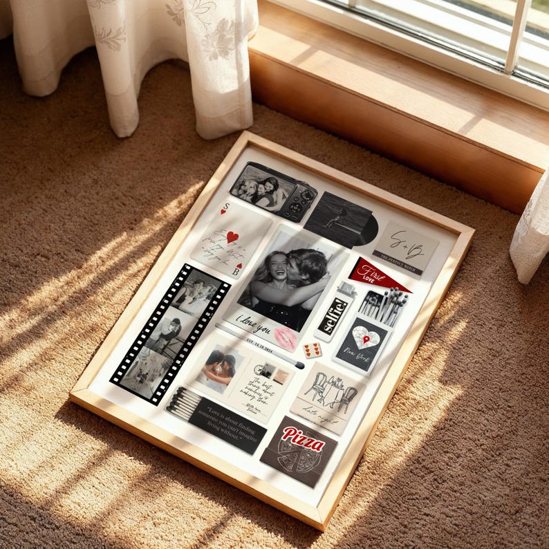 May include: A framed collage featuring various photographs and mementos. The display includes black and white photos, playing cards, and text that reads "I love you", "Selfie!", and "Pizza". The frame is light-colored.