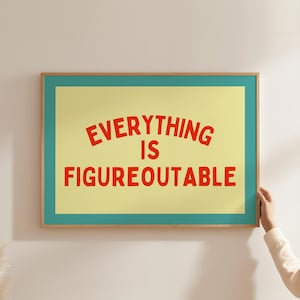 Könnte beinhalten: Gerahmter Kunstdruck mit dem roten Schriftzug "EVERYTHING IS FIGUREOUTABLE". Das Kunstwerk hat einen gelben Hintergrund, einen türkisfarbenen Rahmen und einen Holzrahmen. Eine Person hält den Druck.