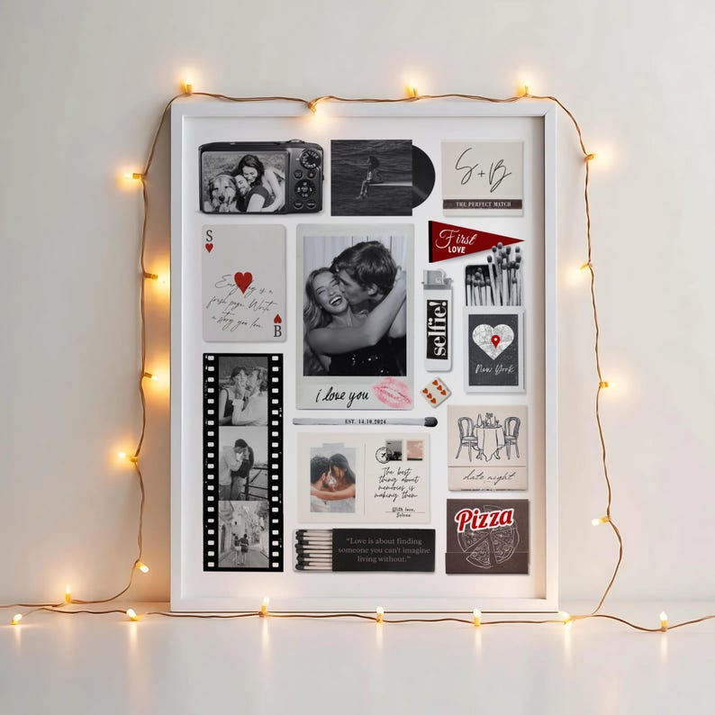 May include: A white framed collage featuring photos, cards, and decorative elements. Includes a photo of two people, a film strip, and the text "I love you" and "selfie!". Fairy lights surround the frame.