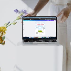 May include: A laptop computer with a white background showing a colorful graphic with the text "Book Title" and a chart with a green bar and yellow stars.