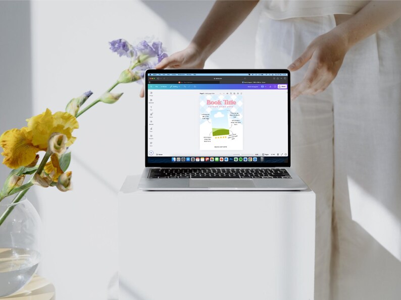 May include: A laptop computer with a white background showing a colorful graphic with the text "Book Title" and a chart with a green bar and yellow stars.