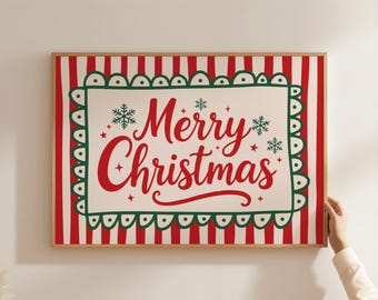 May include: A framed Christmas sign with a red and white striped background. The sign features the words "Merry Christmas" in red script, surrounded by snowflakes and a green scalloped border. The frame is a light brown colour.