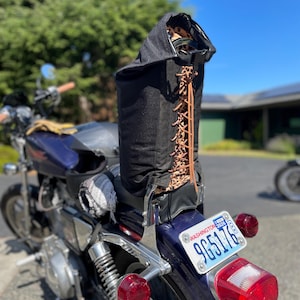 Könnte beinhalten: Eine schwarze Motorradtasche mit Leopardenmuster-Innenraum und braunen Lederschnürsenkeln ist auf einem blauen Motorrad montiert. Die Tasche steht aufrecht und ist am Sitz befestigt. Das Motorrad hat ein Washingtoner Kennzeichen.