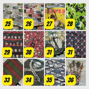 K&ouml;nnte beinhalten: Ein Set aus 12 Stoffquadraten mit verschiedenen Mustern. Die Muster umfassen Bienen, Katzen, eine japanische Szene, Tarnung, Puppen, Totenk&ouml;pfe und Knochen, ein Schiff, einen Totenkopf und Schwerter, Wellen und eine Hand mit einem Auge. Die Quadrate sind von 25 bis 36 nummeriert.