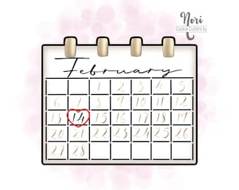 May include: A white calendar with gold accents and a red heart around the number 14, indicating Valentine's Day. The calendar is for the month of February.
