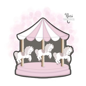 May include: A cookie cutter in the shape of a carousel with three white horses. The carousel has a pink and white striped canopy and a pink base. The text "Nori Cookie Cutters by" is in the upper right corner.