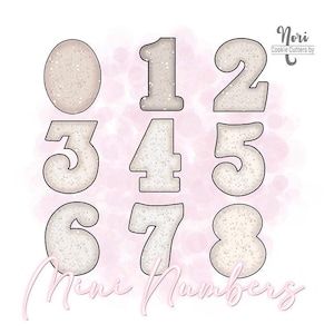 May include: Set of eight mini cookie cutters shaped like the numbers 0 through 8. The cutters are made of silver metal and have a sparkly, glittery finish.