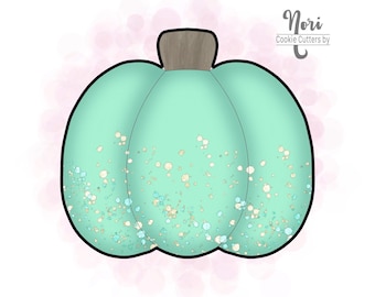 以下が含まれることがあります： 黒い輪郭と茶色の茎が付いた、ターコイズ色のカボチャのクッキーカッター。カボチャは、白、青、金色のキラキラ光る斑点で飾られています。「Nori Cookie Cutters by」の文字が右上隅にあります。