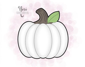 以下が含まれることがあります： 白いかぼちゃのクッキーカッターで、茶色の茎と緑の葉が付いています。クッキーカッターはピンクと白の背景の上にあります。