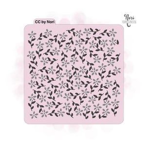 May include: A pink cookie cutter stencil with a repeating pattern of small black flowers and leaves. The stencil is labeled "CC by Nori" in the top left corner and "Nori Cookie Cutters by" in the top right corner.