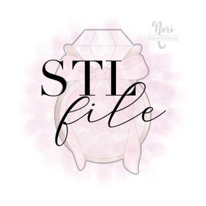 May include: A diamond ring-shaped cookie cutter design with a bow, the words "STI file" are written in black. The background has a soft pink watercolor effect. The text "Nori Cookie Cutters by" is in the upper right corner.